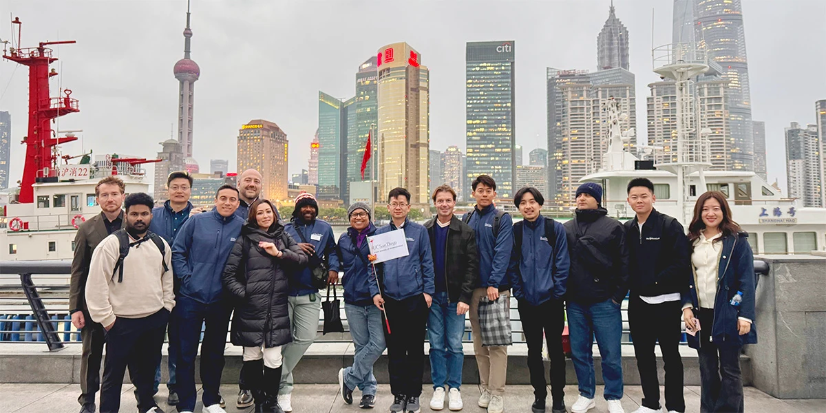 Rady MBA participants holding a UC San Diego sign on Shanghai’s waterfront during their March 2025 China immersion.